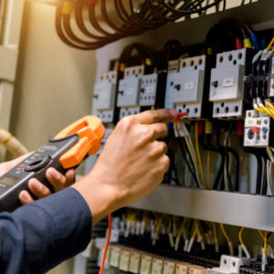 Electrician engineer work  tester measuring  voltage and current of power electric line in electical cabinet control.